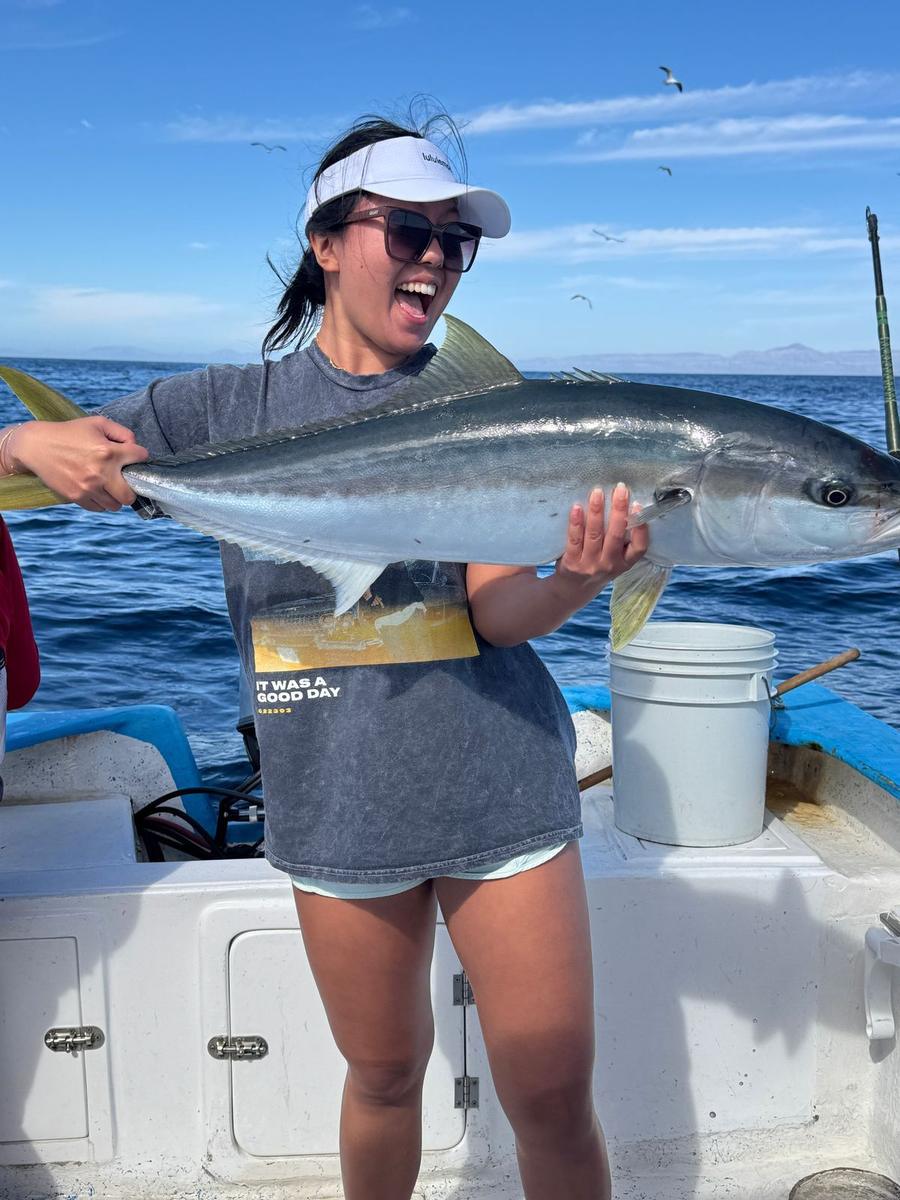 Angler celebrating a yellowtail caught in the Sea of Cortez